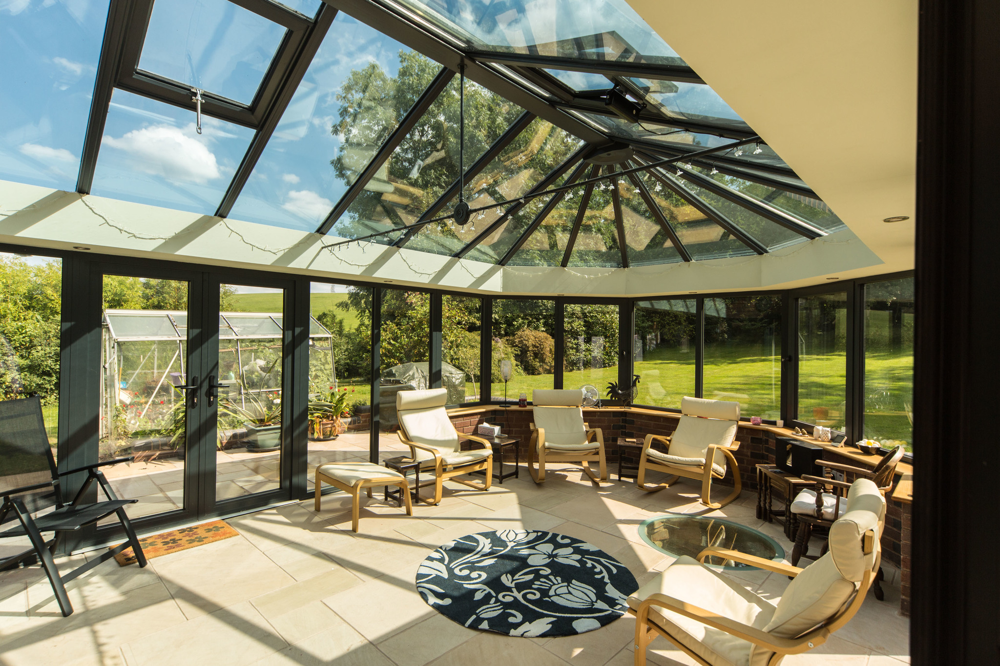 A {large} conservatory with a glass roof offering {stunning views} in Tewkesbury.